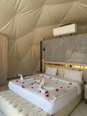 a bed in a tent with swans made out of flowers at Rum Royal Dunes Camp & tour in Wadi Rum