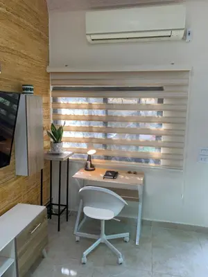 an office with a desk and a chair and a window at Tayoon Host in Jerash