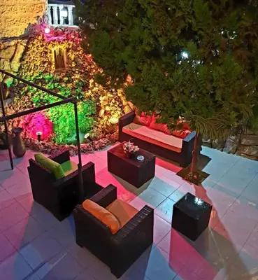 a patio with couches and tables and lights at Tell Madaba in Madaba