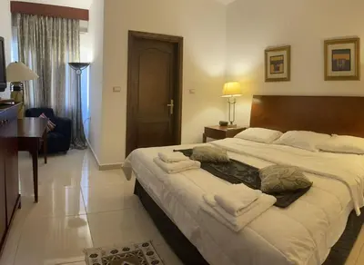 a bedroom with a large bed with towels on it at Tell Madaba in Madaba