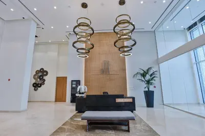 a lobby with a chair and a chandelier at Abdali Views Apartments in Amman