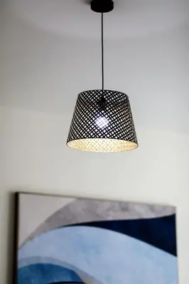 aendant light hanging over a television with a picture at Abdali Views Apartments in Amman
