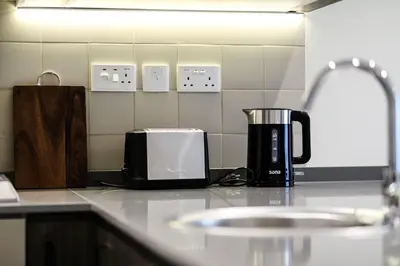 a kitchen counter with a coffee maker and a toaster at Abdali Views Apartments in Amman