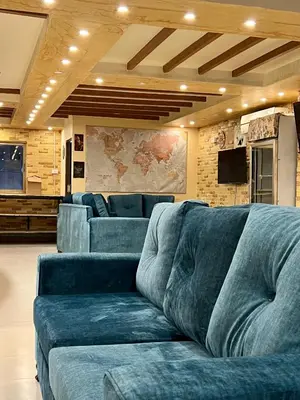 a living room with a blue couch in a room at Raqeem Hotel in Wadi Musa