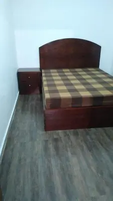 a bedroom with a bed with a checkeredkered floor at Fog Mountain Hotel Rooms & sauna in Jaḩrāʼ