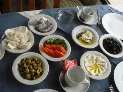 a blue table with plates of food on it at Fog Mountain Hotel Rooms & sauna in Jaḩrāʼ