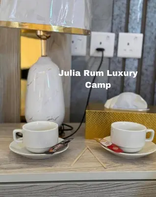 a table with two cups and a vase on it at JULIA RUM lUXURY CAMP in Wadi Rum