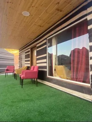 a porch with red chairs and a large window at JULIA RUM lUXURY CAMP in Wadi Rum