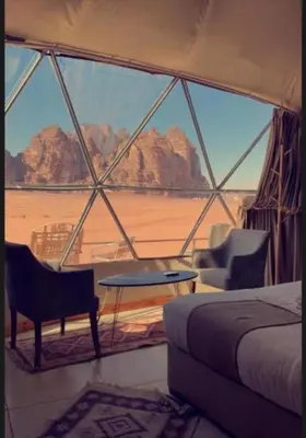 a room with a bed and a view of the desert at JULIA RUM lUXURY CAMP in Wadi Rum