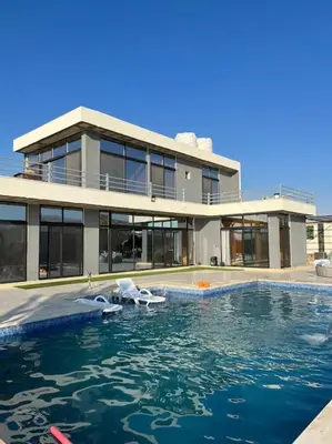 a large house with a swimming pool in front of it at The Legend Villa فيلا الاسطوره in Sowayma