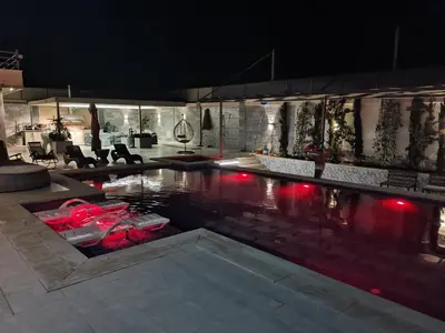 a swimming pool with red lights in a building at The Legend Villa فيلا الاسطوره in Sowayma