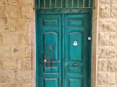 a green door in a stone building with at Shams House in Amman