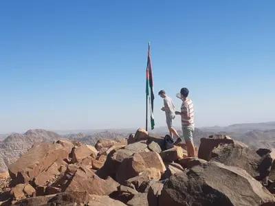 two people standing at the top of a mountain at Mad Mix camp in Wadi Rum