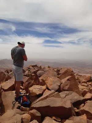 a man standing on top of a rocky mountain at Mad Mix camp in Wadi Rum