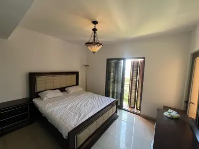 a bedroom with a bed and a chandelier at one bedroom apartments aqaba on for family only 2 swimming pool Tala bay for family only in Aqaba
