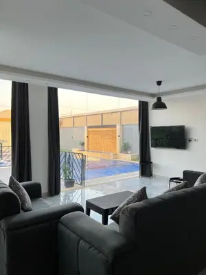 a living room with two couches and a swimming pool at Aroma Mountain Dead Sea in Sowayma