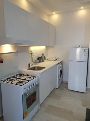 a kitchen with a stove and a sink and a refrigerator at Deir Ghbar-Studio in Amman