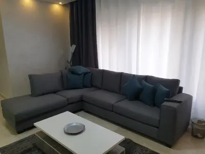 a living room with a couch and a table at Deir Ghbar-Studio in Amman