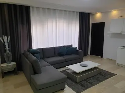 a living room with a couch and a table at Deir Ghbar-Studio in Amman