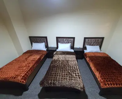 three beds are lined up in a room at Petraone in Wadi Musa