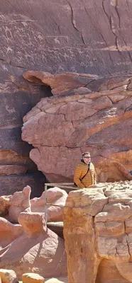 a man standing on top of a rock formation at Ammar Rum Camp and tours in Wadi Rum