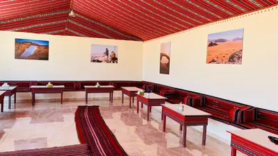 a dining room with tables and pictures on the walls at Ammar Rum Camp and tours in Wadi Rum