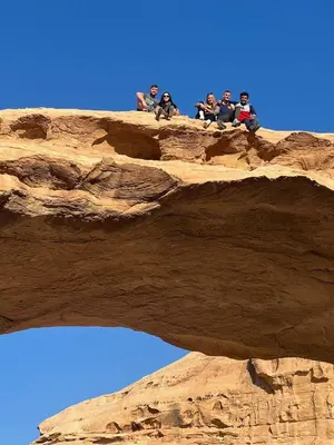 a group of people sitting on a rock formation at Ammar Rum Camp and tours in Wadi Rum