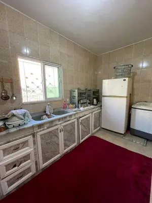 a kitchen with a white refrigerator and a window at Its your choice hostel in Wadi Musa