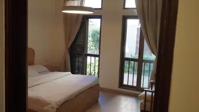 a bedroom with a bed and two large windows at Ground floor apartment by circular pool for families only in Talabay in Aqaba