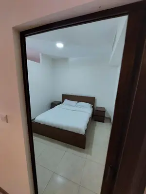 a bedroom with a bed and a large glass window at Ground floor apartment by circular pool for families only in Talabay in Aqaba