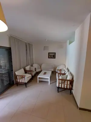 a living room with couches and a table and chairs at Ground floor apartment by circular pool for families only in Talabay in Aqaba