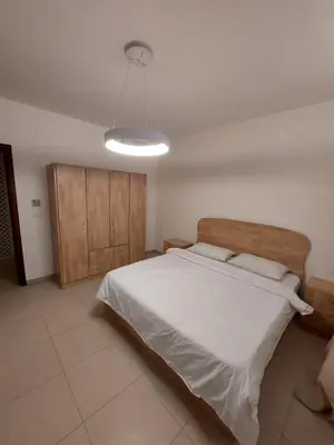 a bedroom with a large bed and a light at Ground floor apartment by circular pool for families only in Talabay in Aqaba