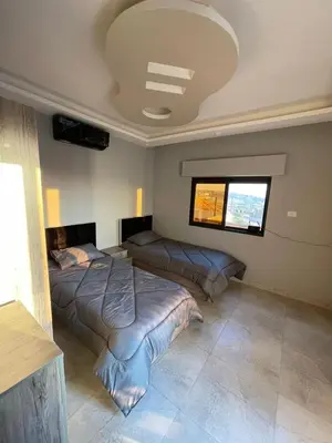 a bedroom with two beds and a window at Villa Jana chalet - Private Villa - Dead Sea - Jordan in Ash Shāghūr