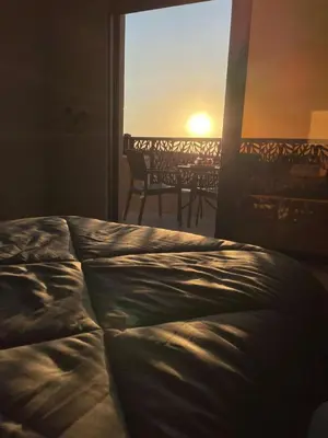 a bedroom with a bed and a view of the ocean at Villa Jana chalet - Private Villa - Dead Sea - Jordan in Ash Shāghūr