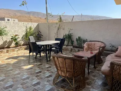 a patio with a table and chairs on a patio at Beida Bedouin House in Al Ḩayy