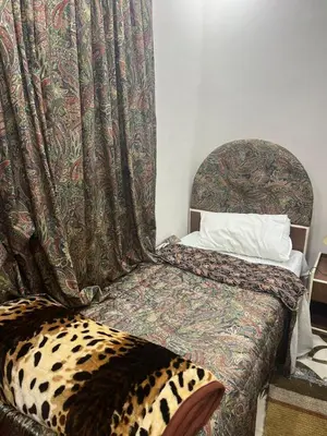 a bedroom with a bed with a cheetah blanket at Beida Bedouin House in Al Ḩayy