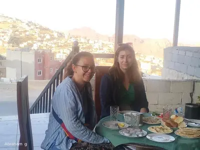 two women sitting at a table with food at ZRIZIRA INN in Wadi Musa