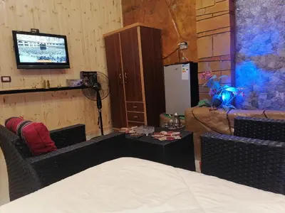 a room with a bed and a tv and a table at Yaso Roof & Apartments in Amman