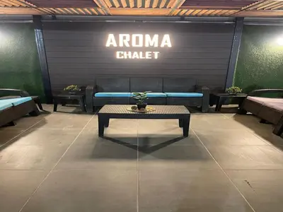 a room with a couch and a table and a sign at Aroma Chalet in Sowayma