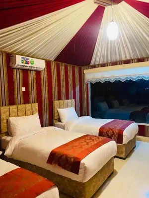 a bedroom with two beds and a tent at Syndebad desert camp in Wadi Rum