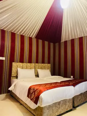a bed in a room with a striped wall at Syndebad desert camp in Wadi Rum