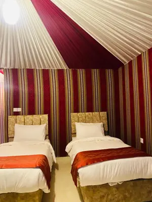 two beds in a room with a striped wall at Syndebad desert camp in Wadi Rum