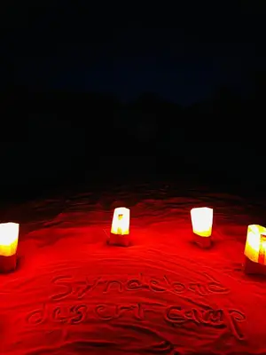 three candles sitting on top of a red table at Syndebad desert camp in Wadi Rum
