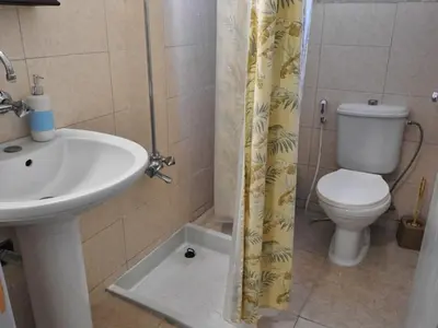 a bathroom with a sink and a toilet at Beit Philodemus in Um Qeis