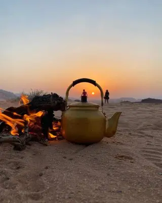 a tea kettle sitting on top of a camp fire at The calm nature of Wadi Rum in Wadi Rum