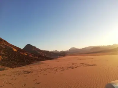 a view of a desert with mountains in the background at The calm nature of Wadi Rum in Wadi Rum