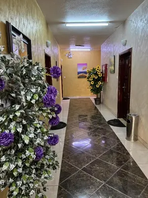 a hallway with purple flowers on the wall at العاصم للشقق الفندقية ALASEM HOTEL APARTMENTS in Aqaba