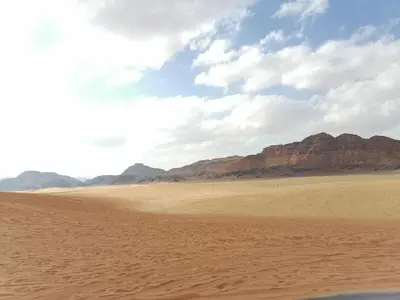 a desert scene with mountains in the background and a sand field at altair luxury rum in Wadi Rum