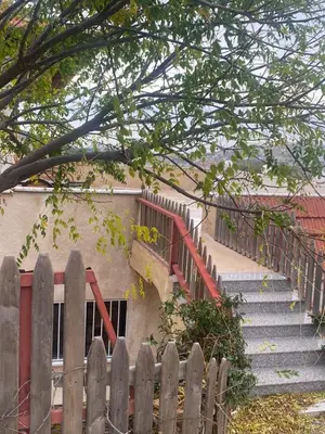 a wooden fence in front of a building with stairs at Green houseجوهره الشمال in Ajloun