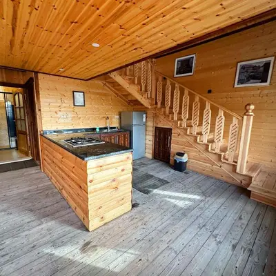 an empty room with a staircase in a wooden cabin at Green House in Zūbiyā